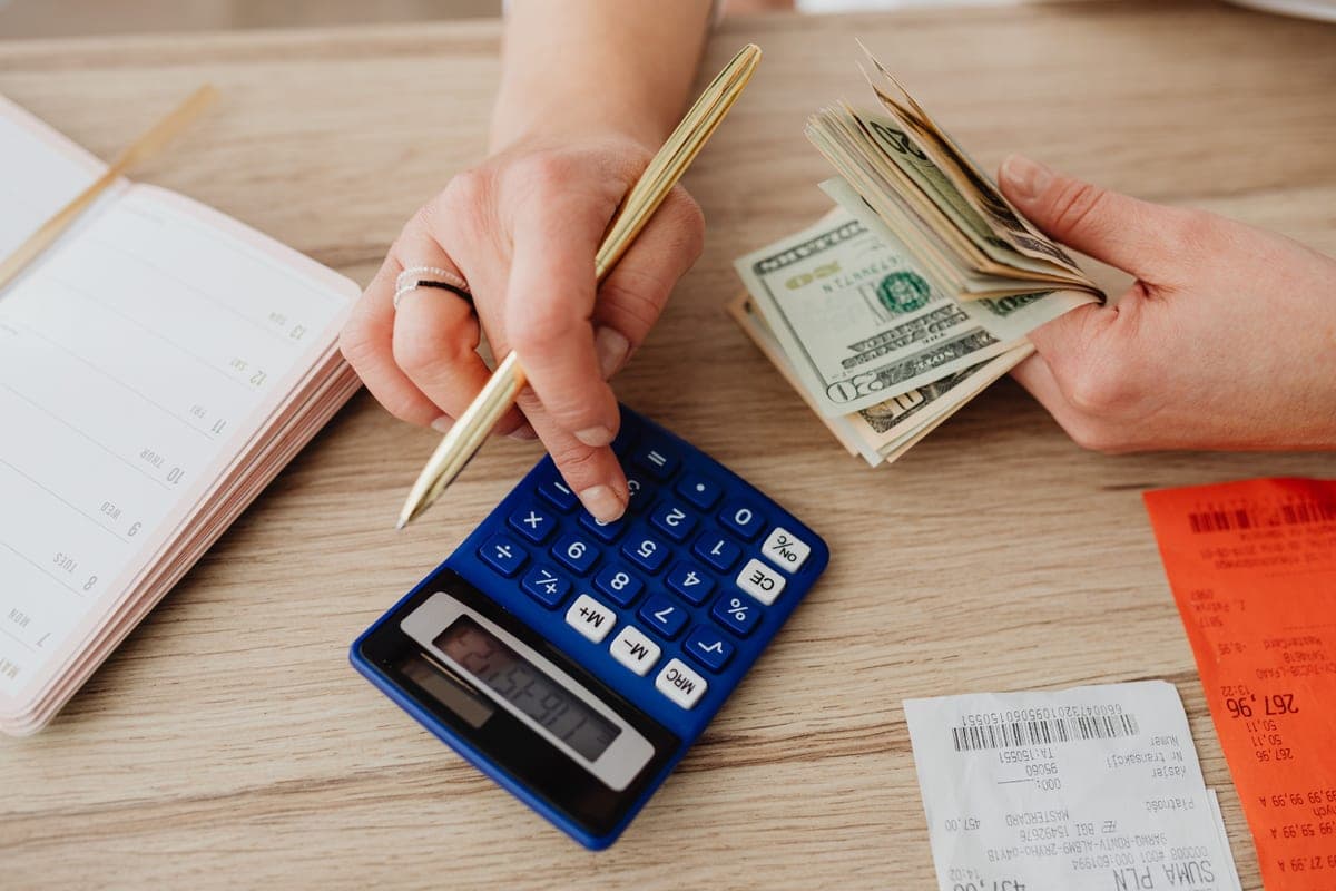 A calculator and notepad on a desk for budgeting