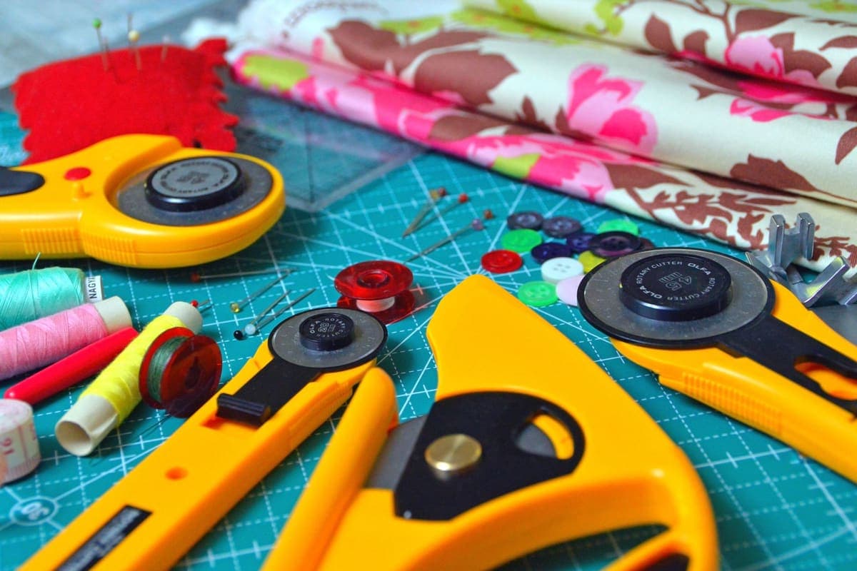 Sewing tools and folded fabrics laid out on a cutting mat