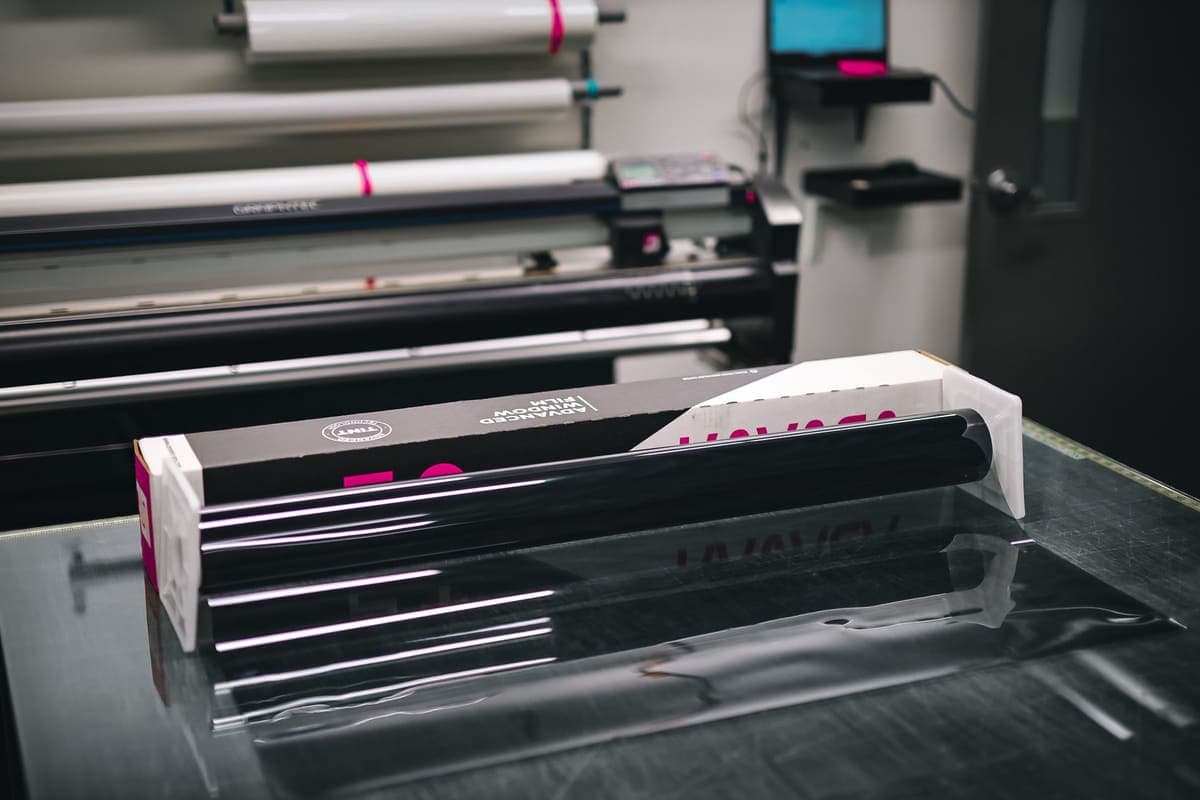 A roll of glossy vinyl material in a print workshop
