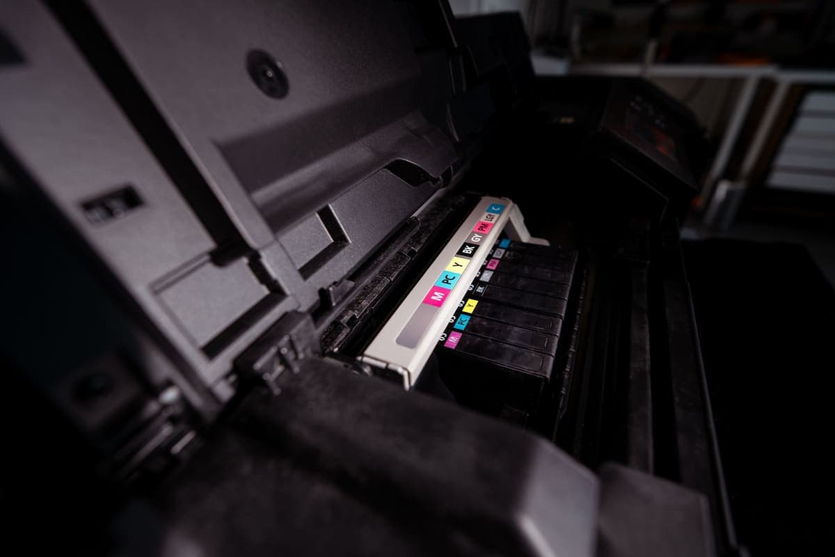 An open inkjet printer showing its ink cartridges