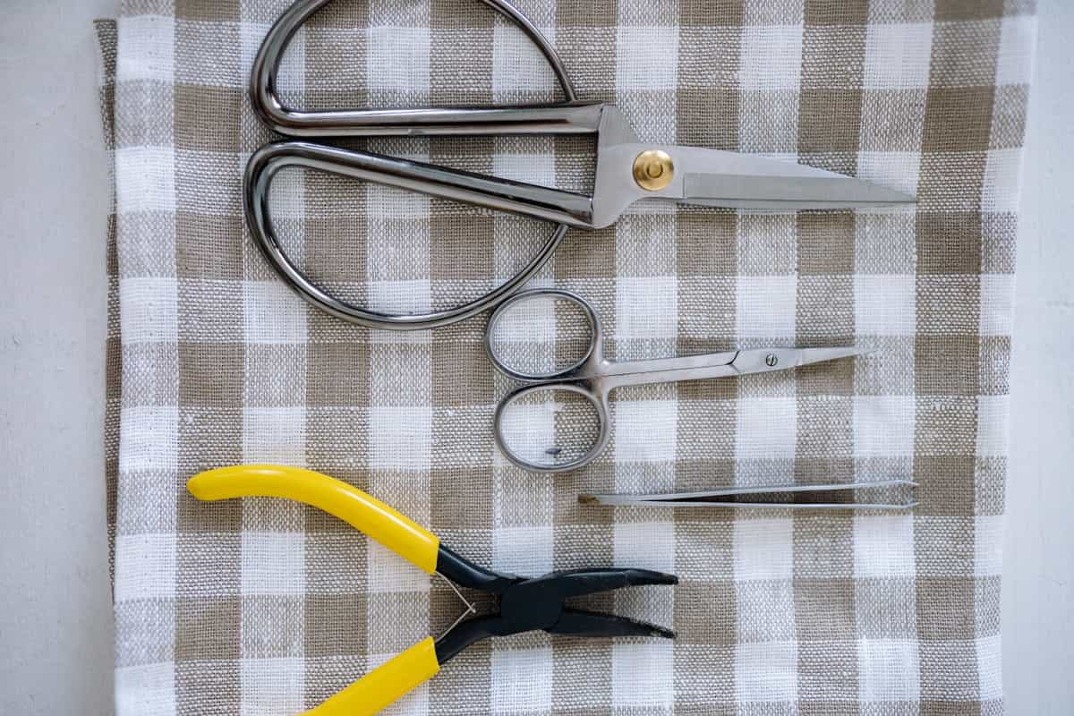 Craft tools including scissors and fine picks on a work surface